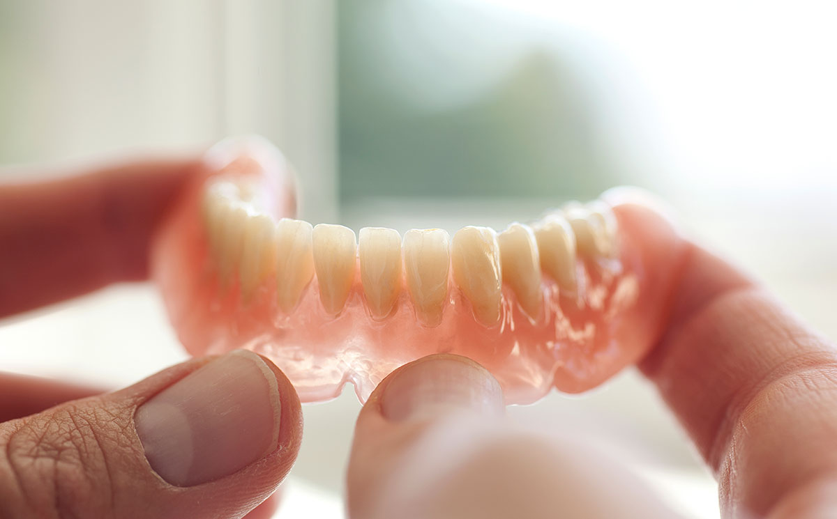 Dental technician holding immediate dentures