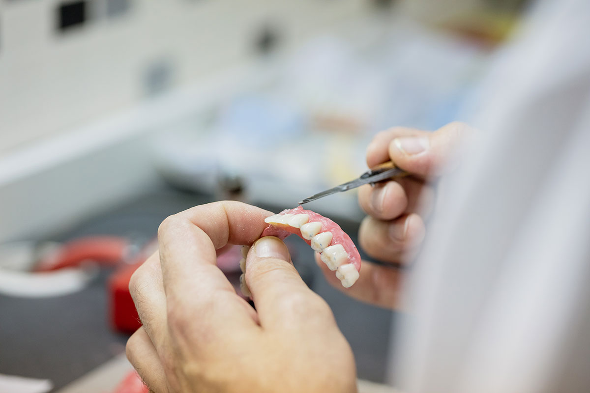 A dentist performing denture repair services